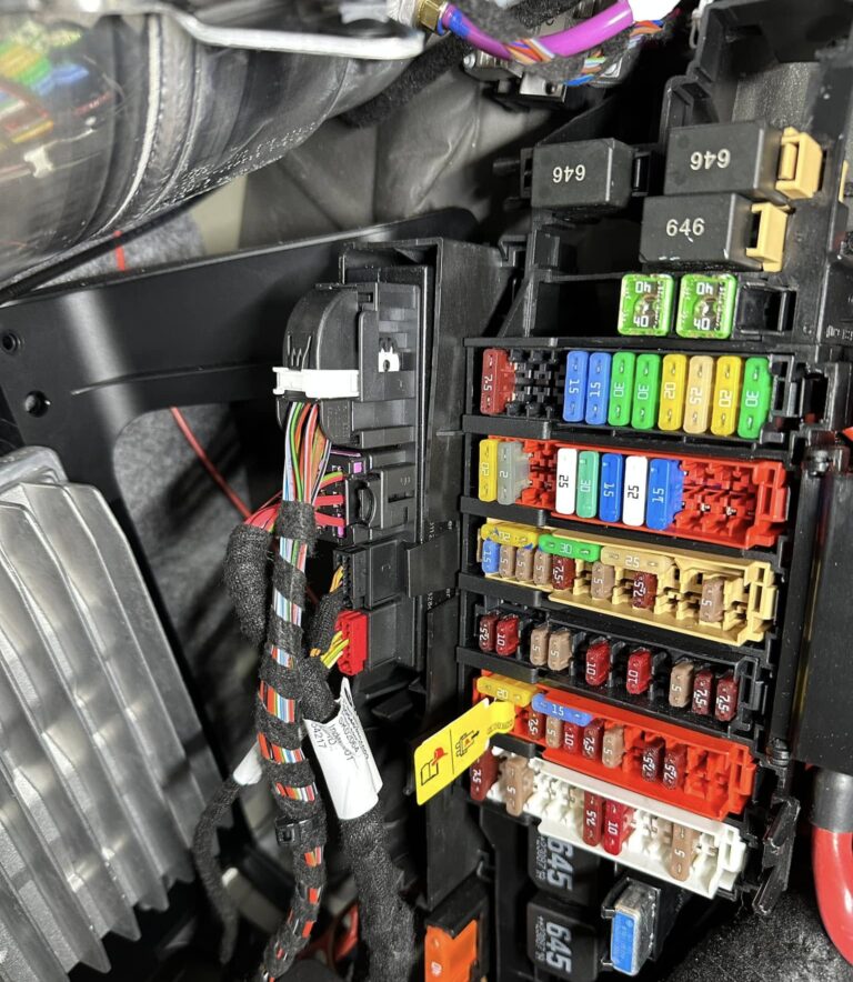 Technician installing Audi retrofit hardware on vehicle