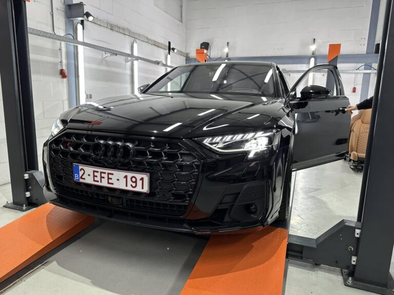 Technician installing Audi retrofit hardware on vehicle